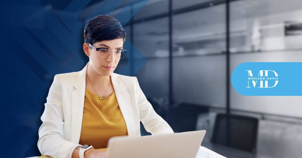 Compliance professional works on a laptop